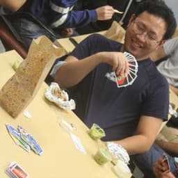 a person holds a deck of Uno cards, smiling