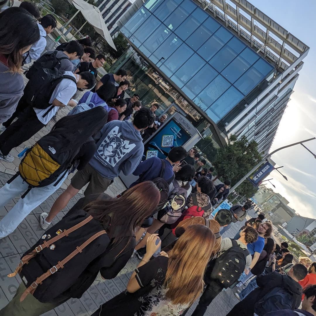 a crowd surrounds a UCSD kiosk at ACM Cyber Kickoff 2024